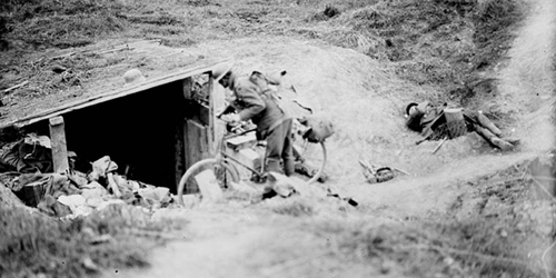 A Canadian cyclist shouting down a dug-out in German for men to come out. Advance East of Arras. September, 1918. Canada. Dept. of National Defence/LAC, MIKAN 3194259